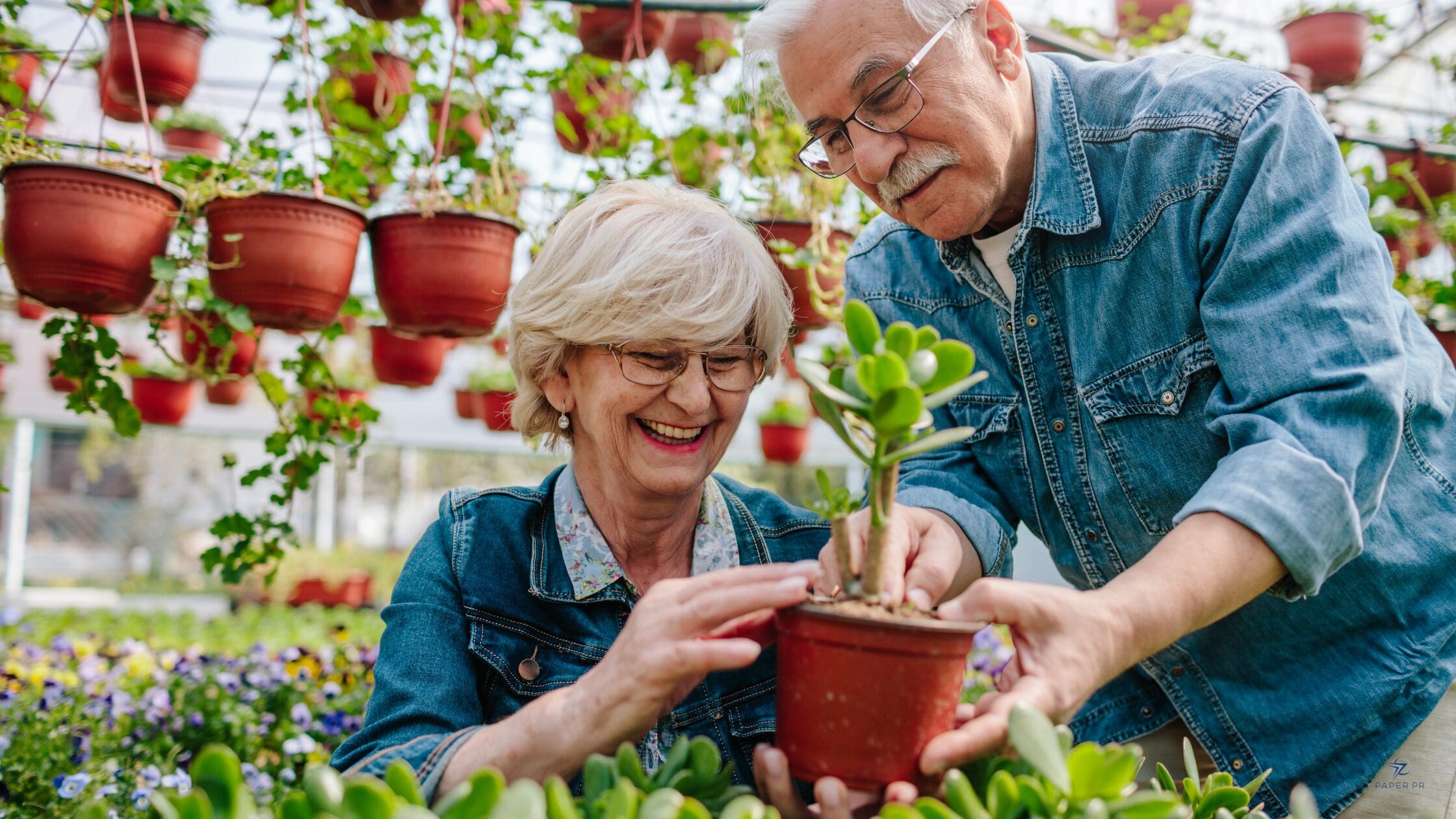 Senior living residents planting flowers at a community center event